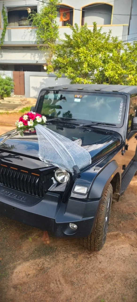 Black Mahindra Thar wedding car with net and flower bouquet