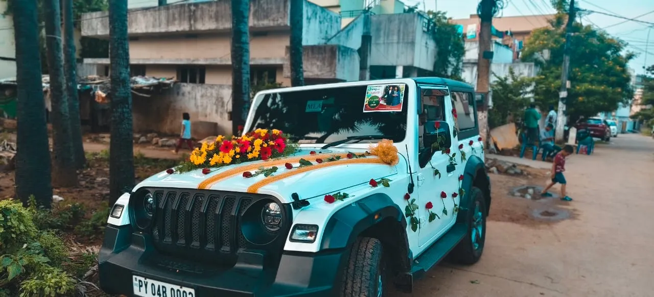 White Mahindra Thar decorated with roses and marigold lines